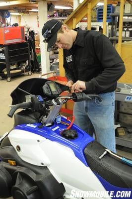 Rob Schatzle cut his teeth wrenching at snowmobile and Jet Ski races. These days he spins wrenches for the Hentges Racing snocross team on the ISOC National circuit is also the owner of RSI Racing. Who better to install the bars on our sled? Rob starts by removing the stock controls. Yamaha controls are two-piece and simply clamp down over the bars with Phillips head screws.  Most sleds are like this for ease of assembly at the factory.