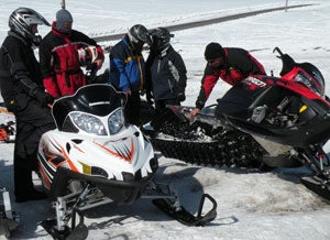 Snowmobile.com mountain rider Kevin Allred, at right, explains how the Polaris powder suspension works.