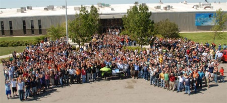 Arctic Cat employees pose around the milestone sled.